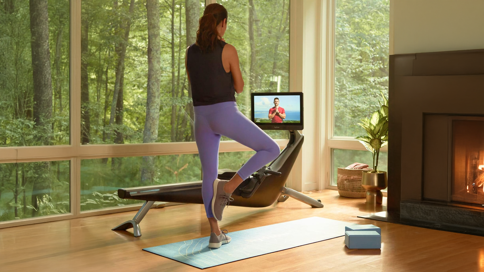 Woman doing yoga pose on Hydrow workout mat