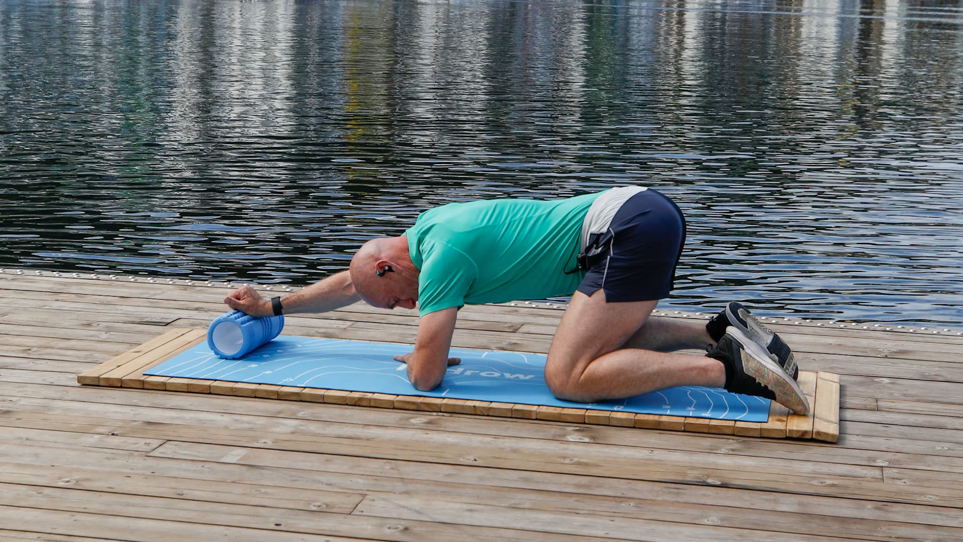 Man doing stretch exercises with foam roller and workout mat