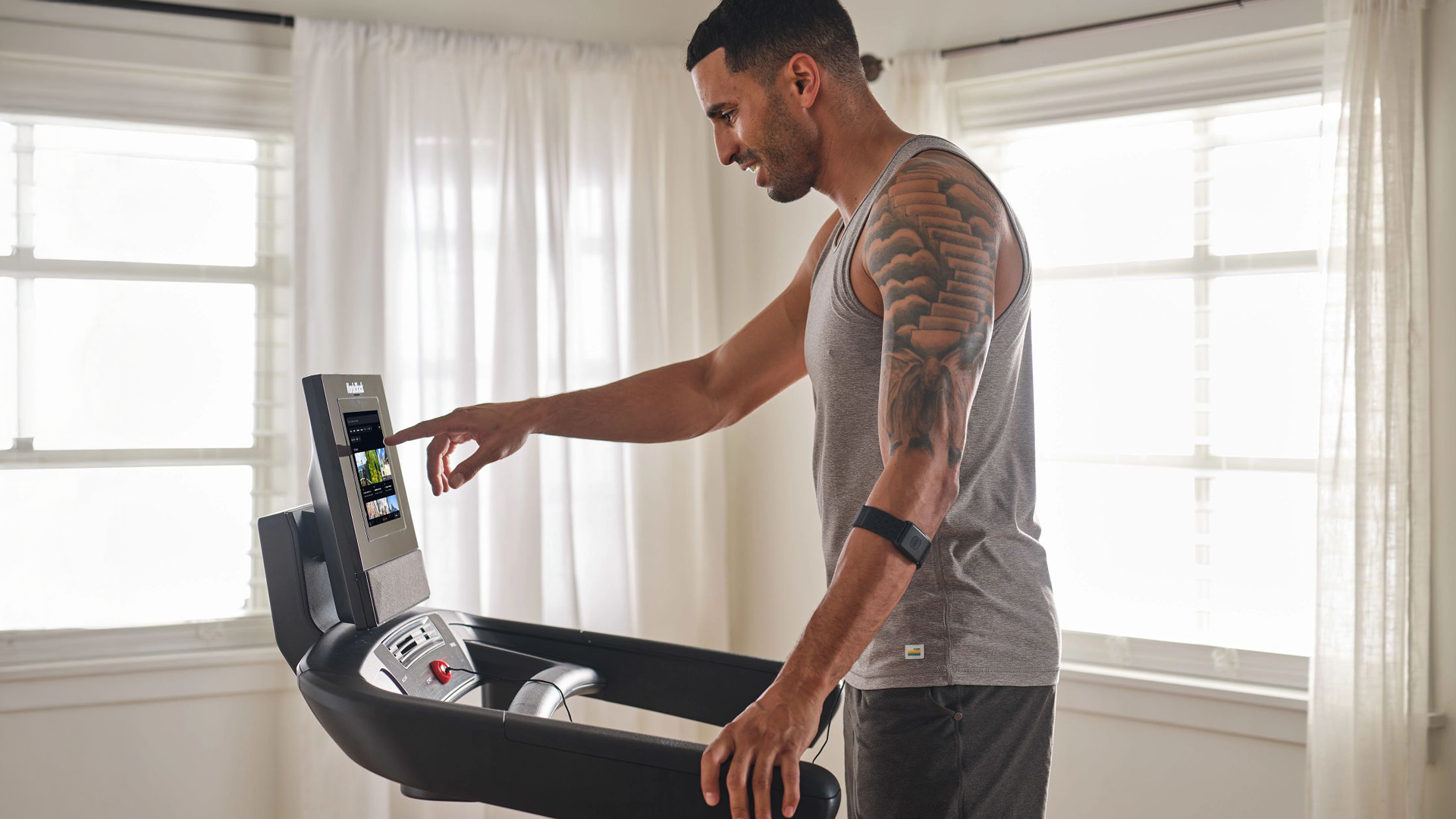Man using touchscreen controls of the NordicTrack T Series 10