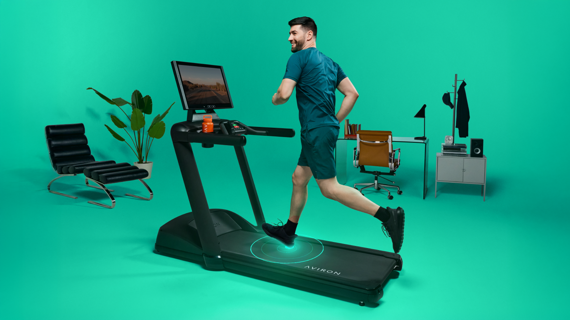 Man running on Aviron Victory Treadmill Plus in green studio