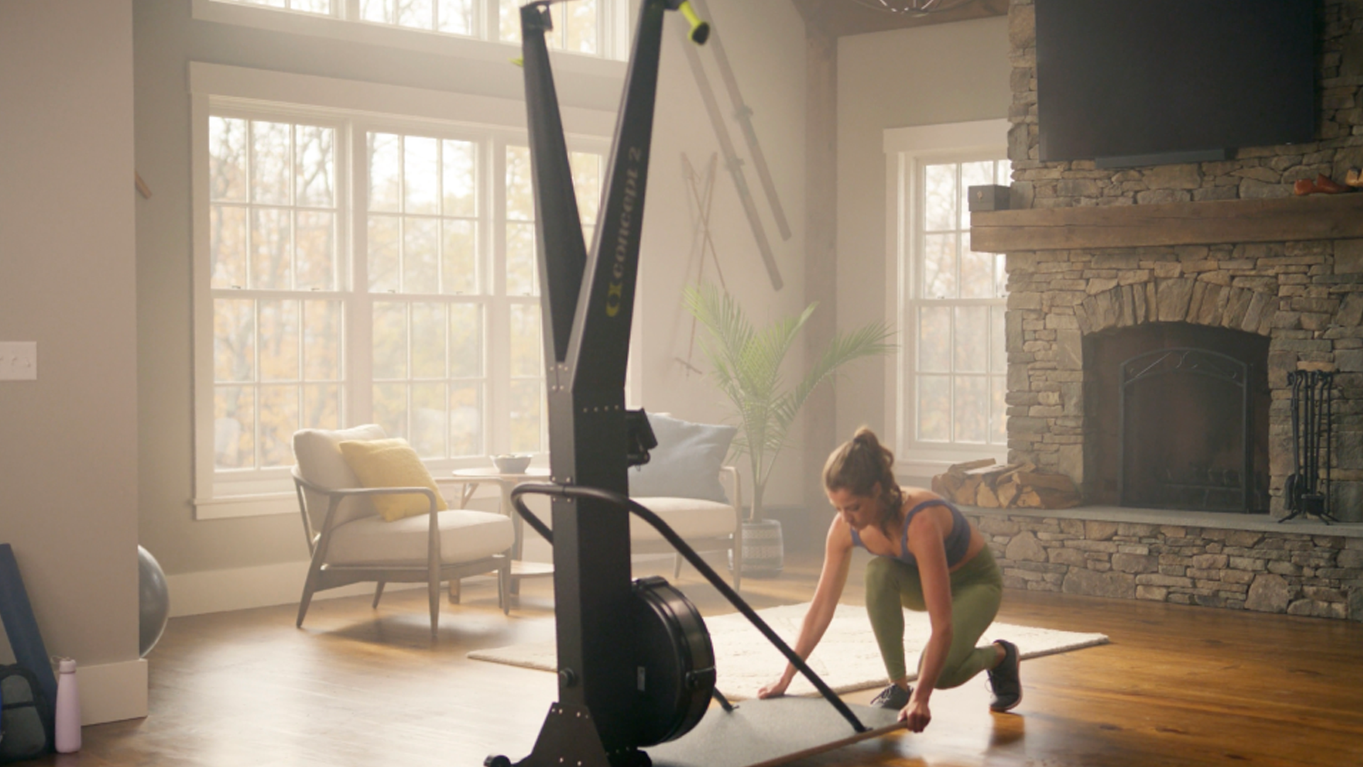 Woman using wheels on floor stand to move the Concept2 SkiErg