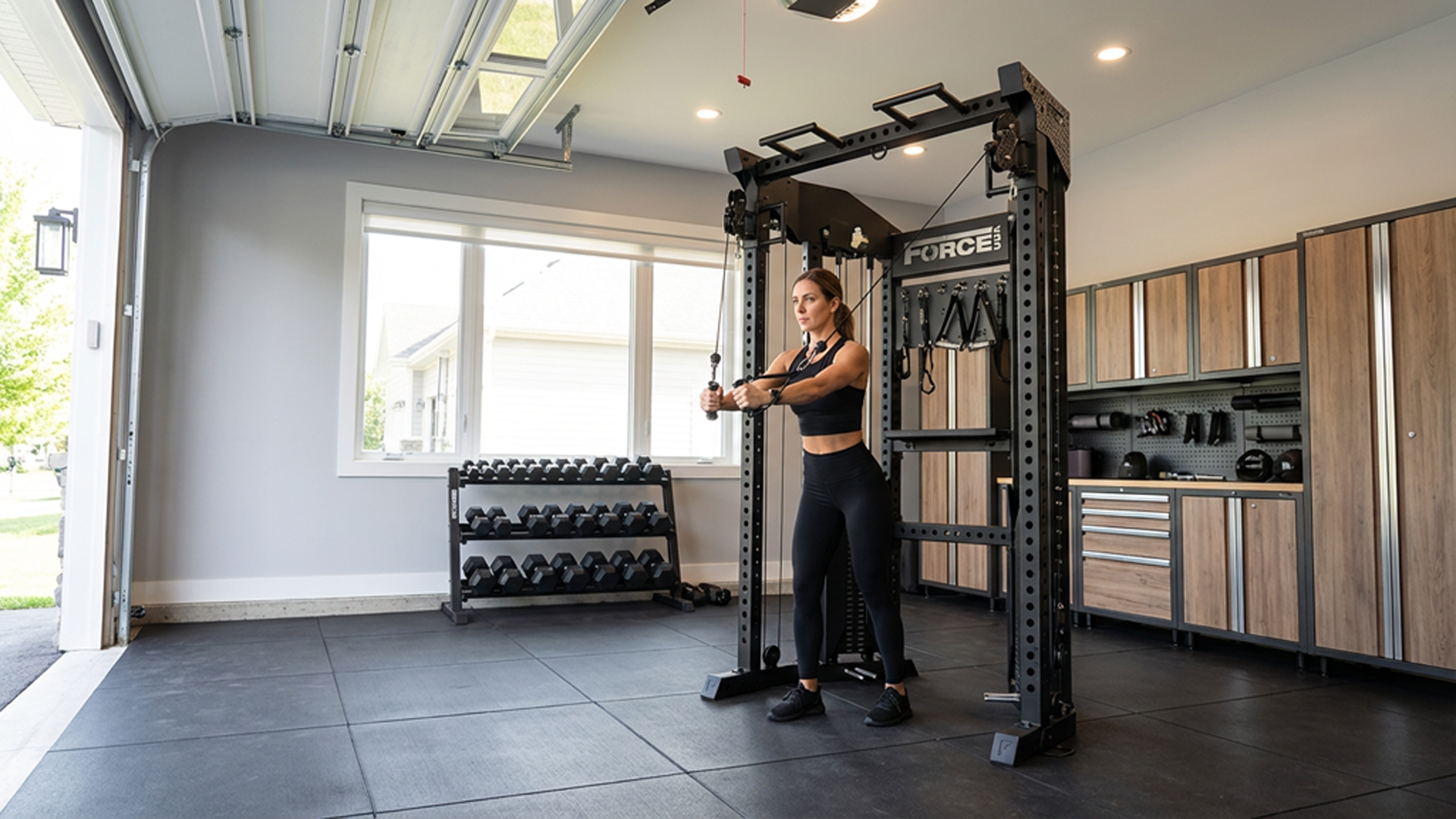 Woman using Force USA Functional Trainer Rack in garage gym