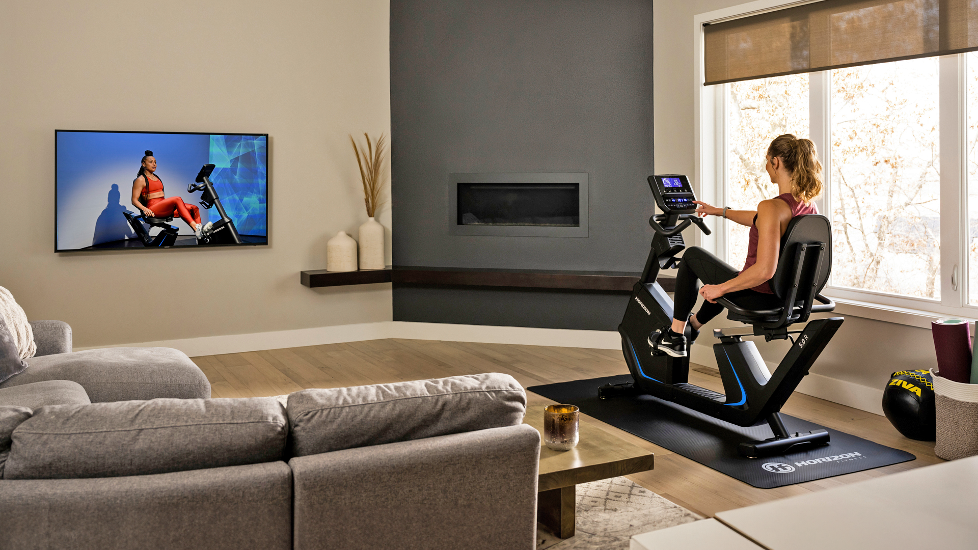 Woman using Horizon 5.0R recumbent bike while streaming to her television