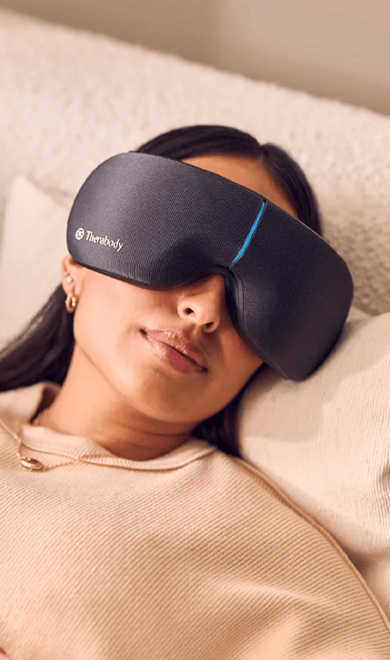 Women relaxing in bed with Therabody SmartGoggles 2nd Gen