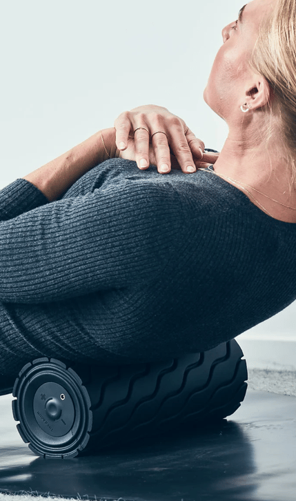 Woman using Therabody WaveRoller on back