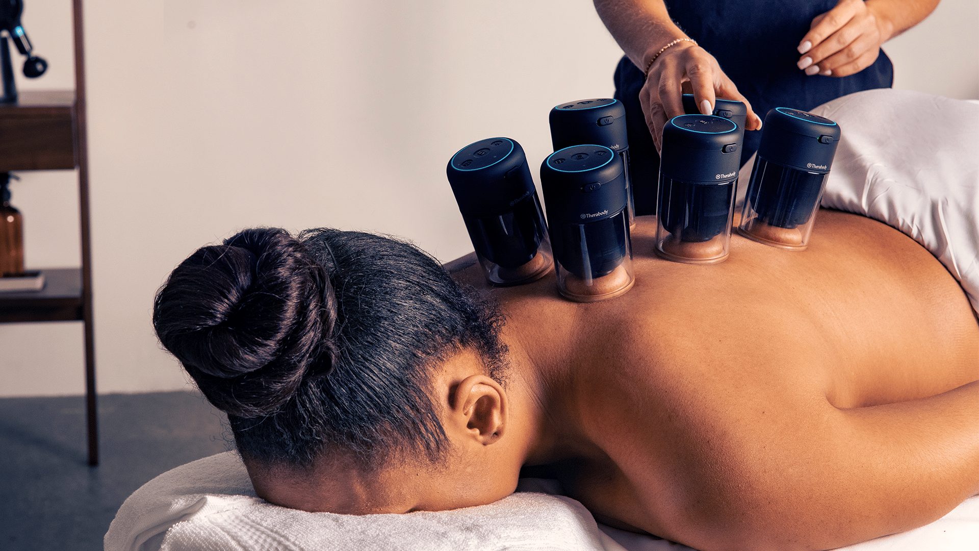 Woman using Therabody TheraCup Cupping on back