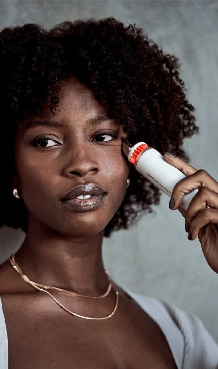 Woman using TheraFace Depuffing Wand on her face