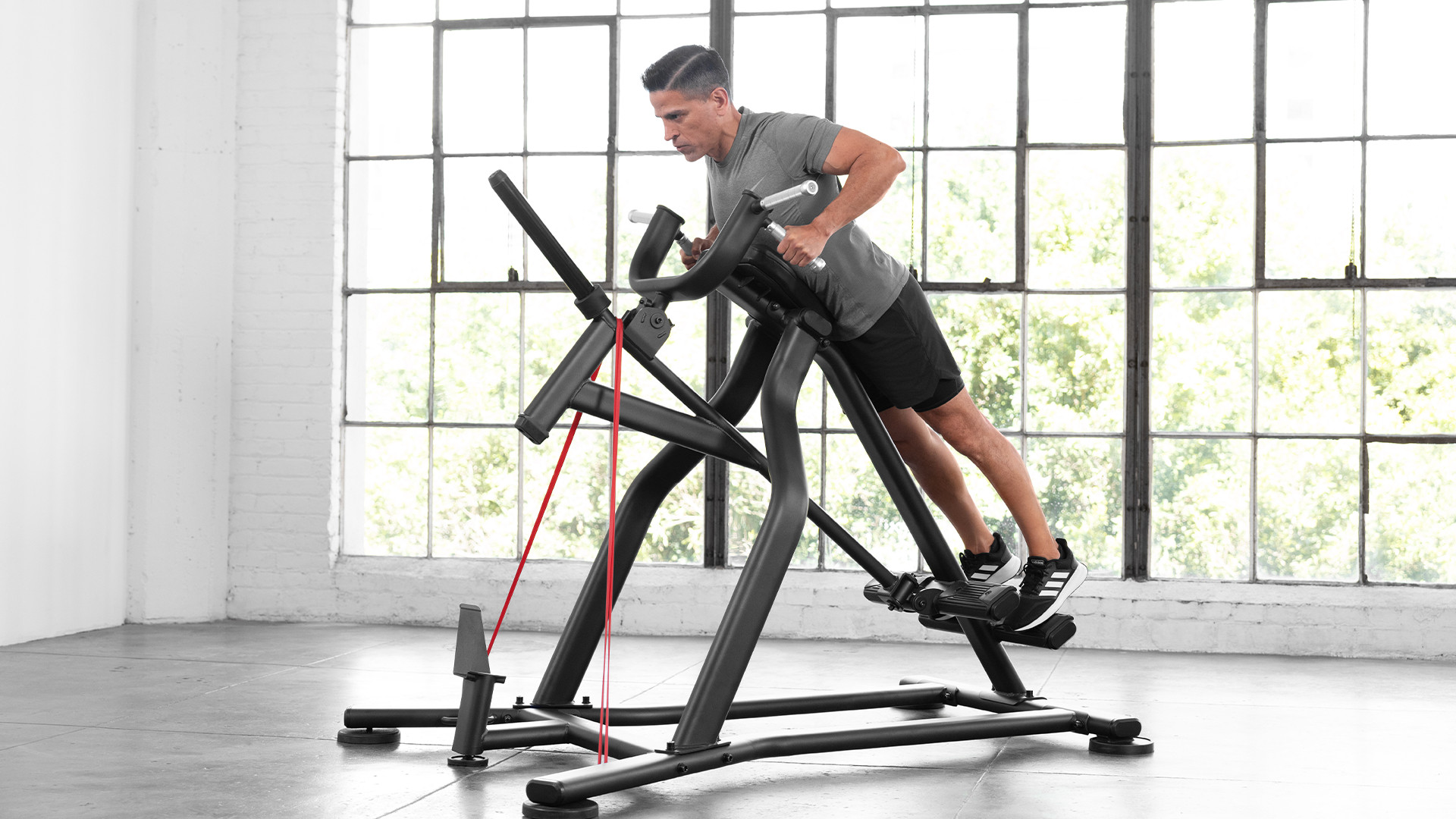 Male using Vision Incline Lever Row in small gym setting