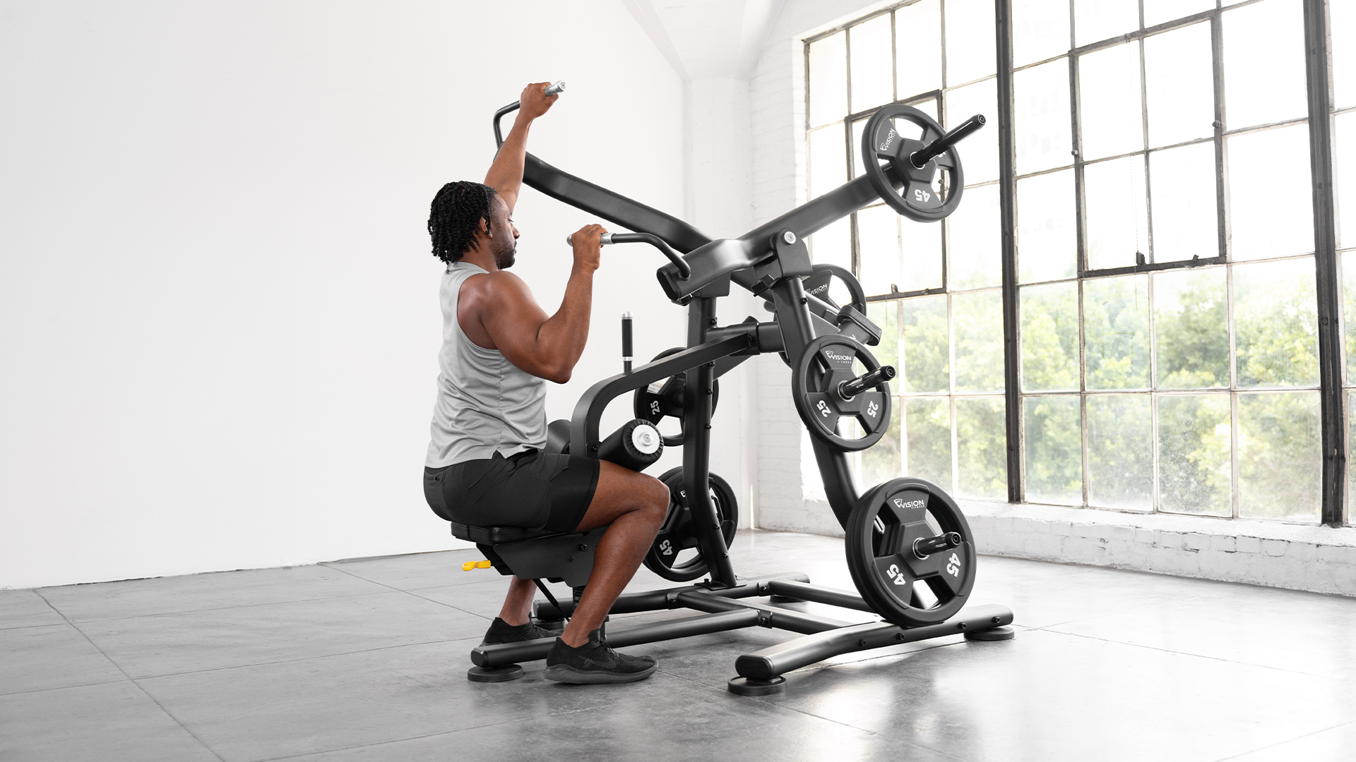 Male using Vision Lat Pulldown in small gym setting