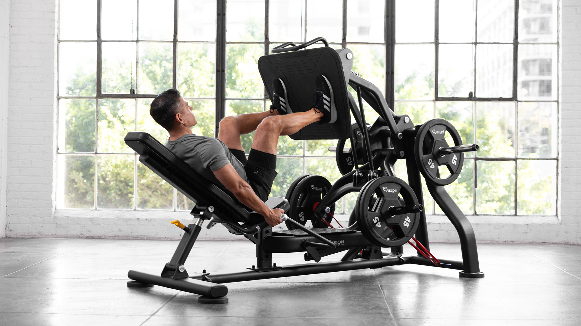 Male using Vision Leg Press in small gym setting