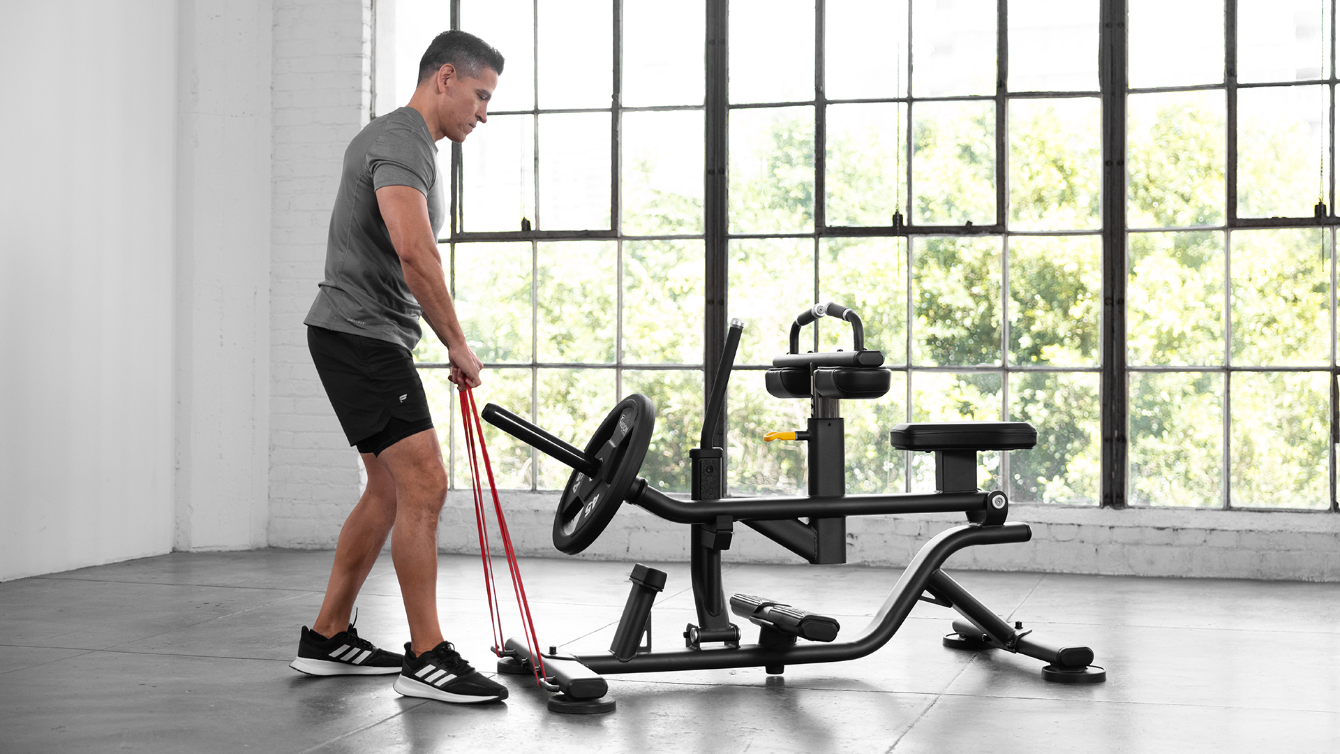 Male using Vision Seated Calf Raise in small gym setting