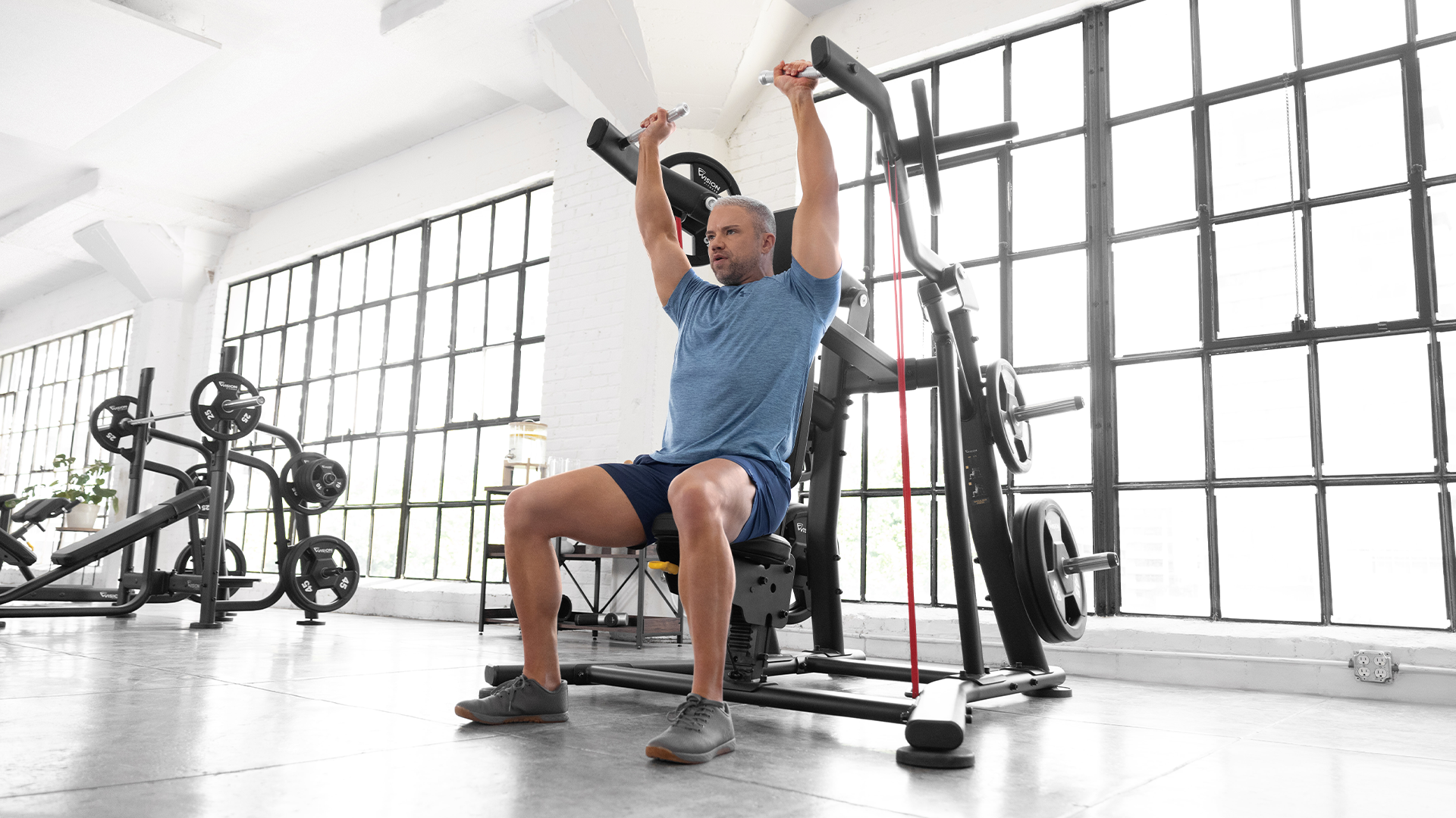 Man using Vision Shoulder Press in small gym setting