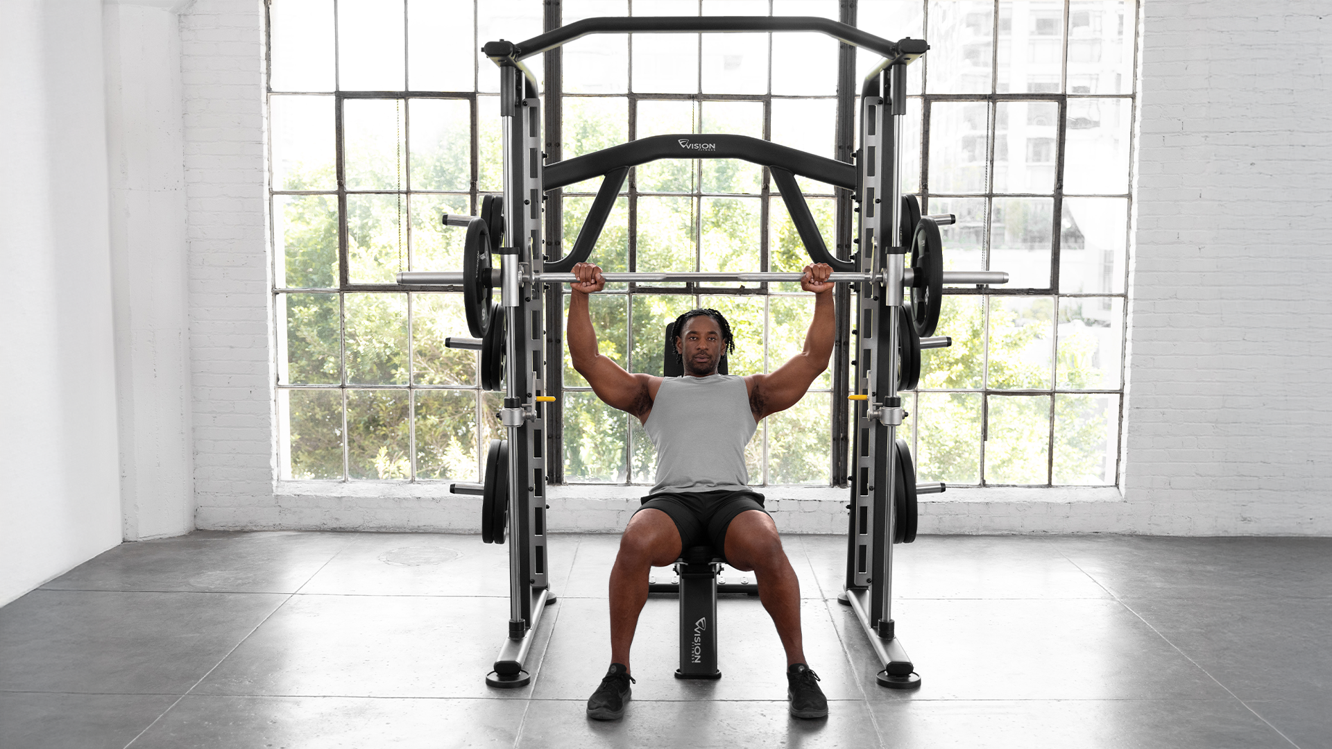 Male using Vision Smith Machine in small gym setting