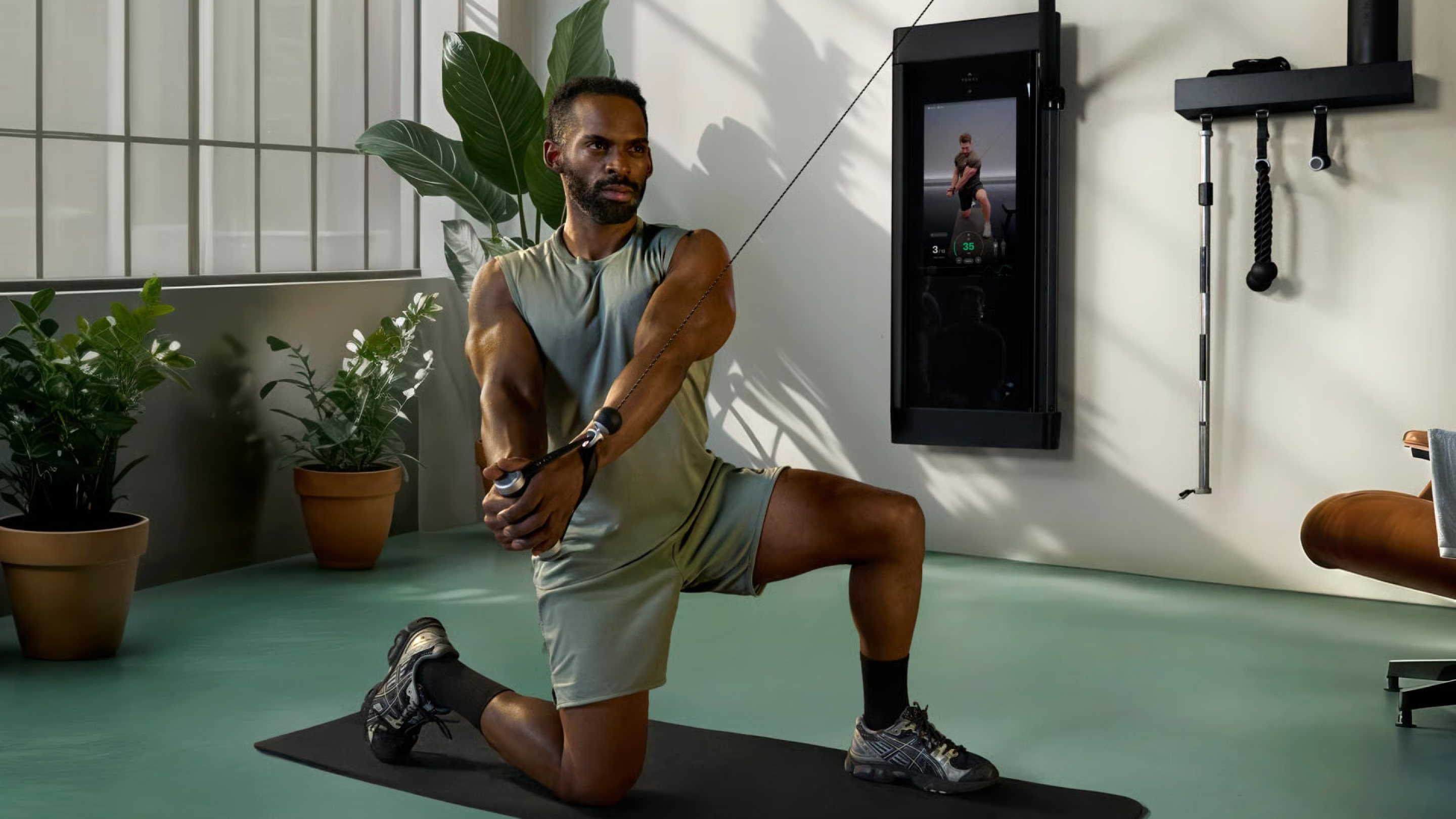 Man working out on Matrix functional trainer in his home workout space