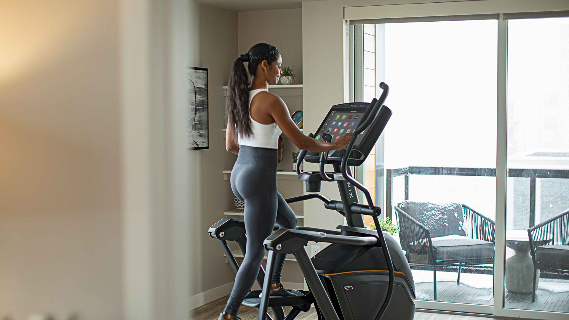 Woman working out on Matrix elliptical in home