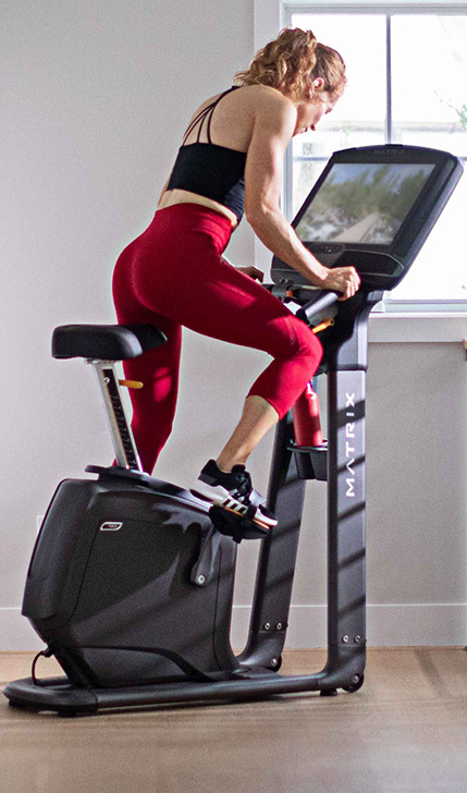 Woman working out on a Matrix upright cycle